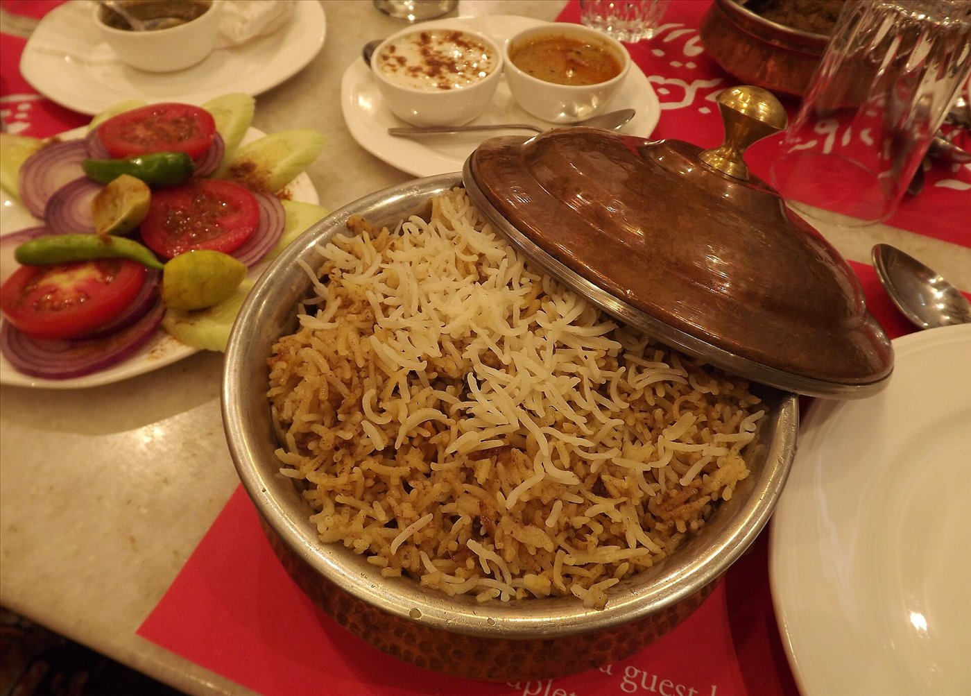 Hyderabadi biryani served with raita, mirchi ka salan and salad