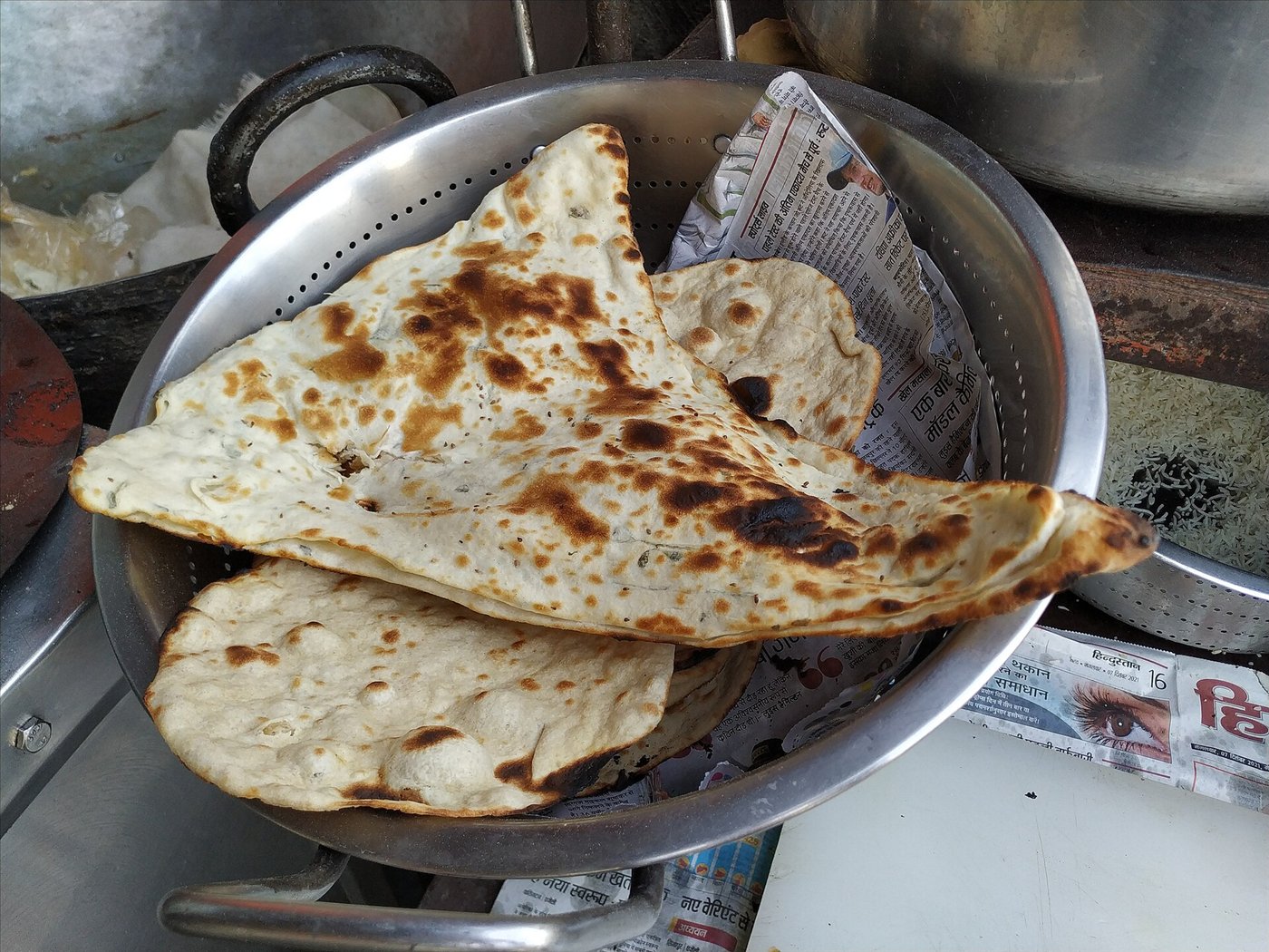 Naan bread baked on the wall of a tandoor