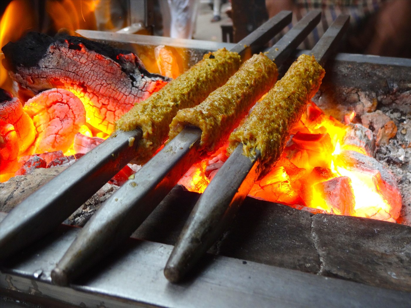 Seekh kebab, long minced meat skewers charred on the grill